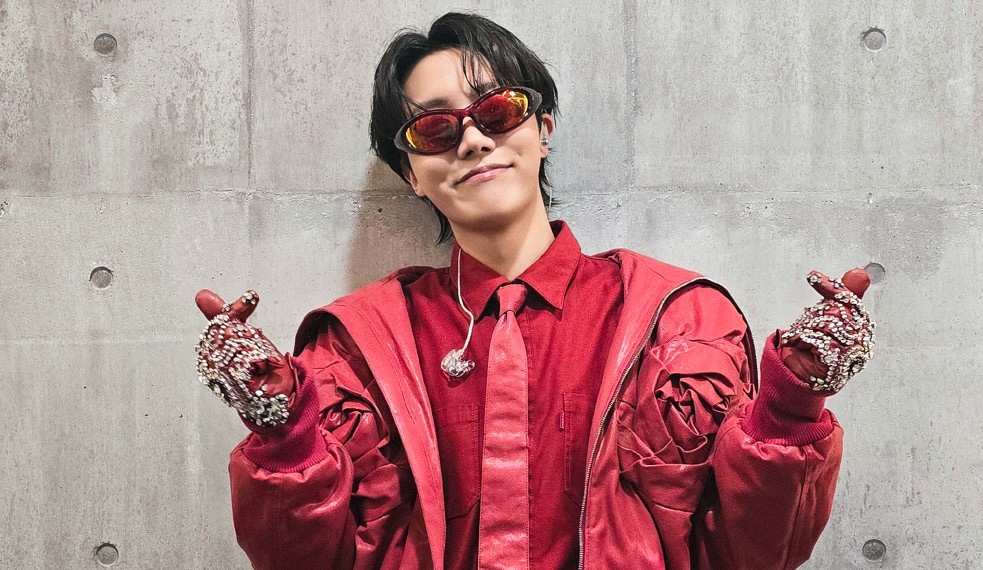 “J-Hope do BTS fazendo o coração coreano, vestindo vermelho, em uma imagem compartilhada no X, relacionada ao show de sua turnê no Japão.”
